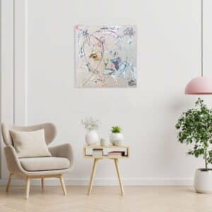 tableau caree art abstract pendu près d'une sofa et plante