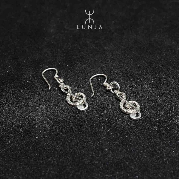 boucles d'oreilles clés de sol en argent sur fond noir