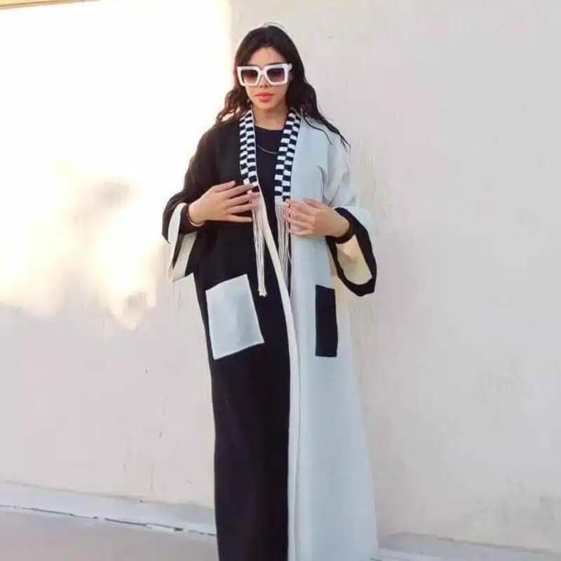 Femme portant un kimono long, blanc et noir, vue de face, style artisanal.