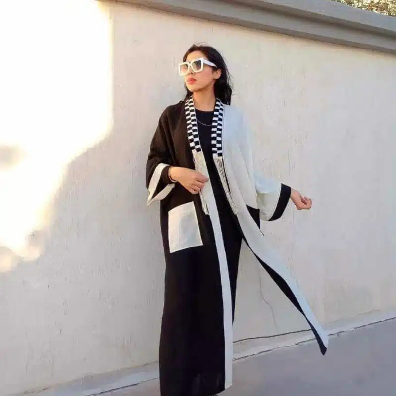 Femme en kimono long, blanc et noir, vue latérale, détail artisanal.